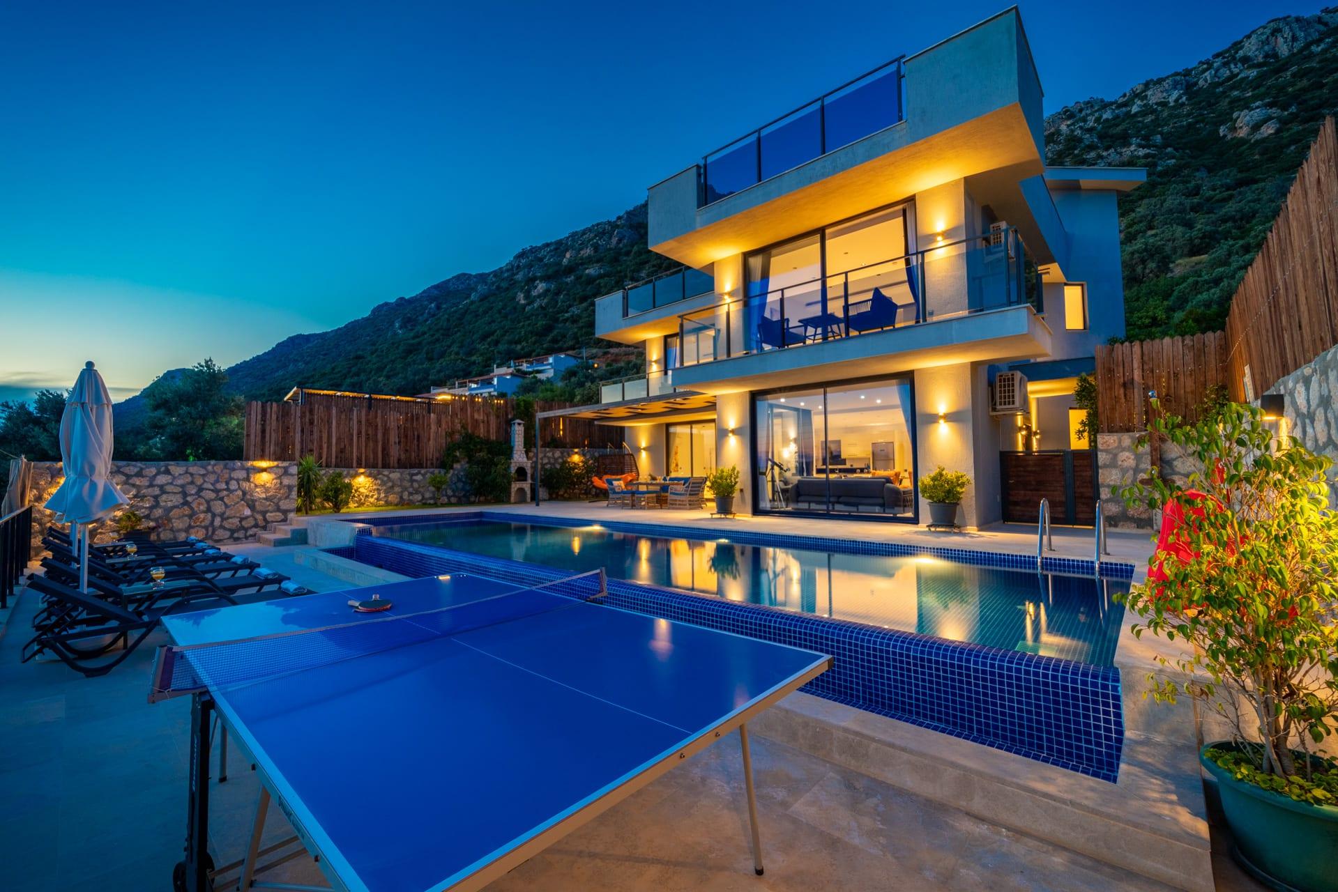 Villa Azde'nin alacakaranlıkta aydınlatılmış cephesi ve özel havuzu